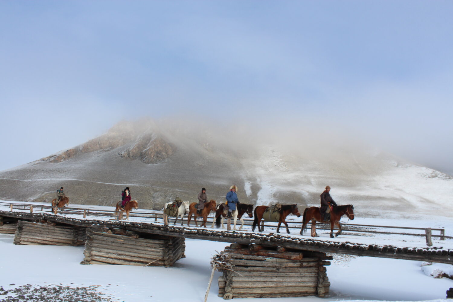 mongolioans riding horses in winter in khuvsgul